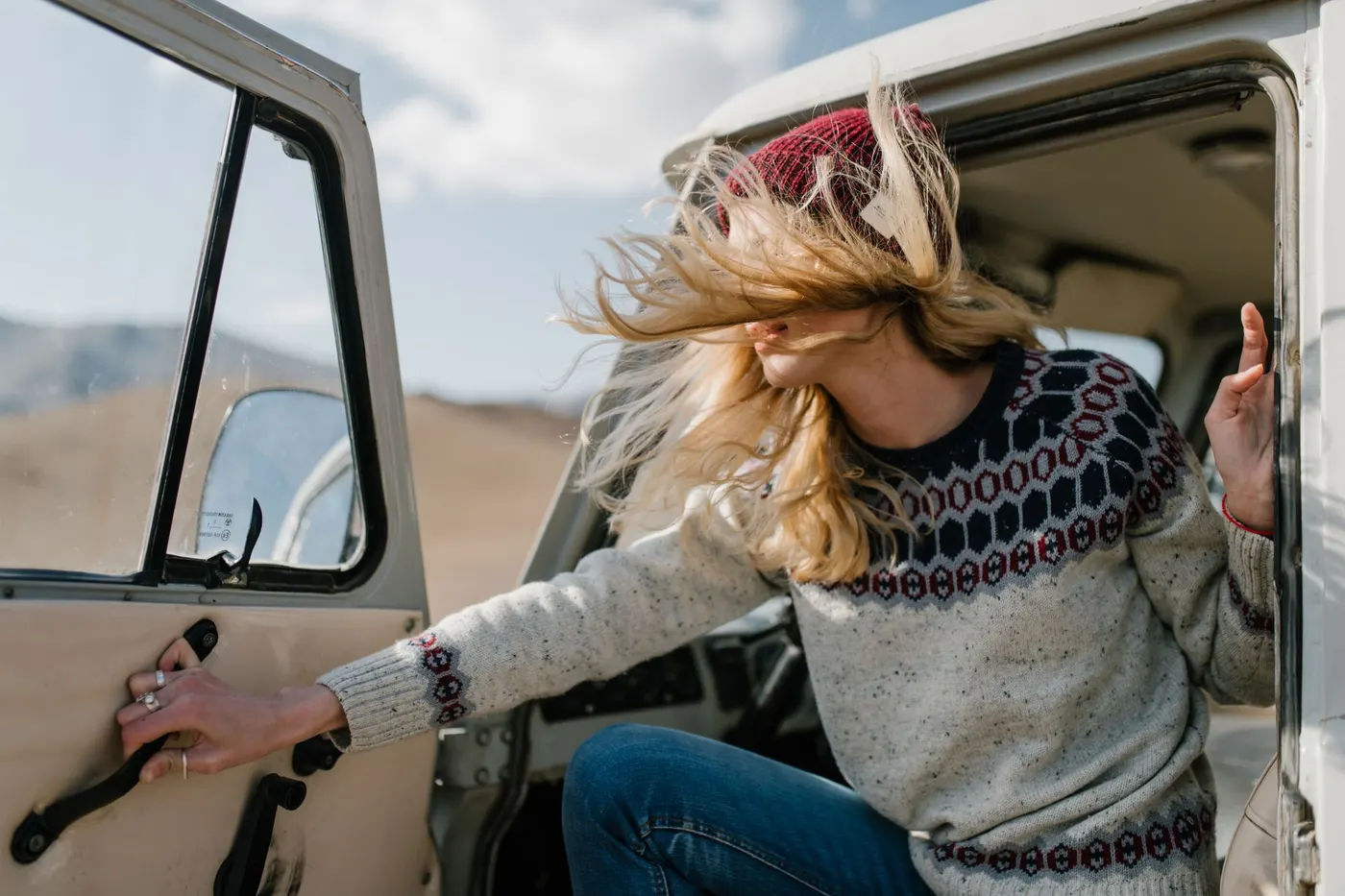 Traveller in a wool sweater and beanie stepping into the wind